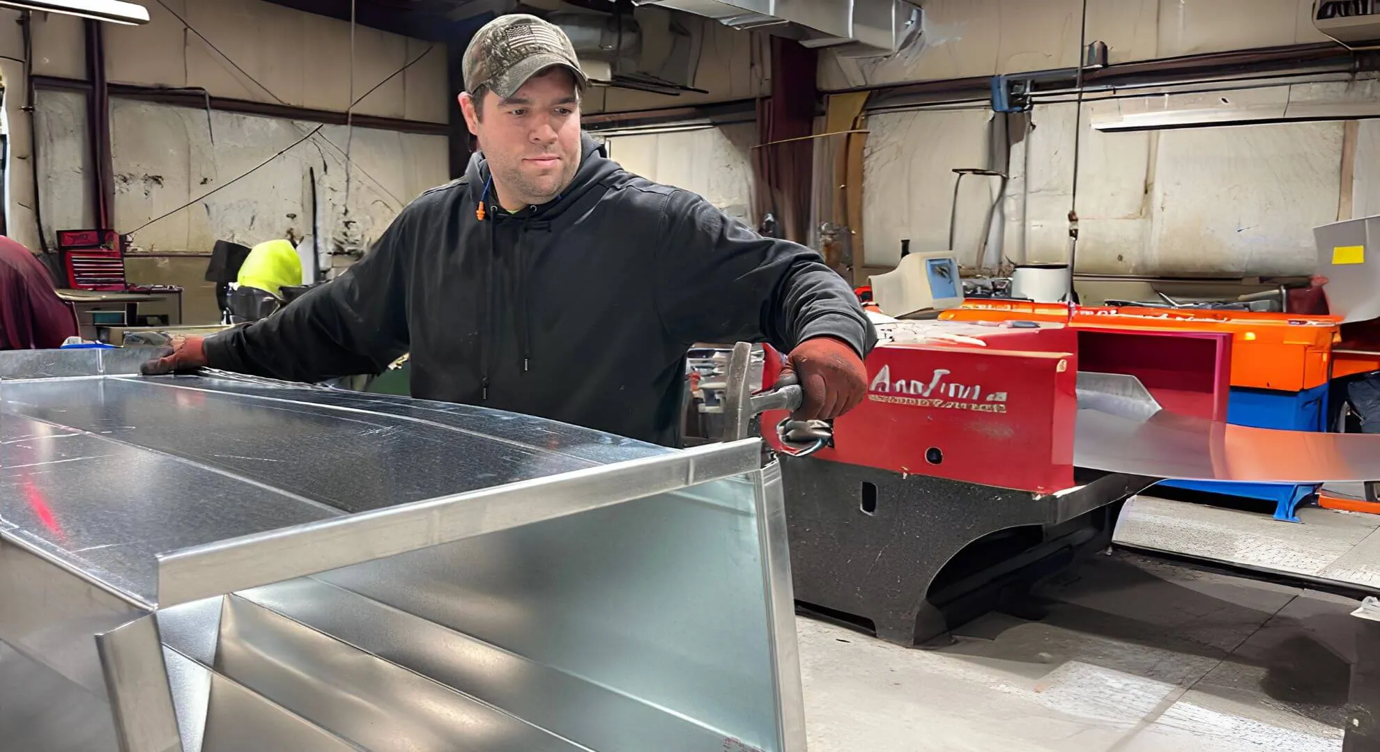 Man hammering a piece of ductwork